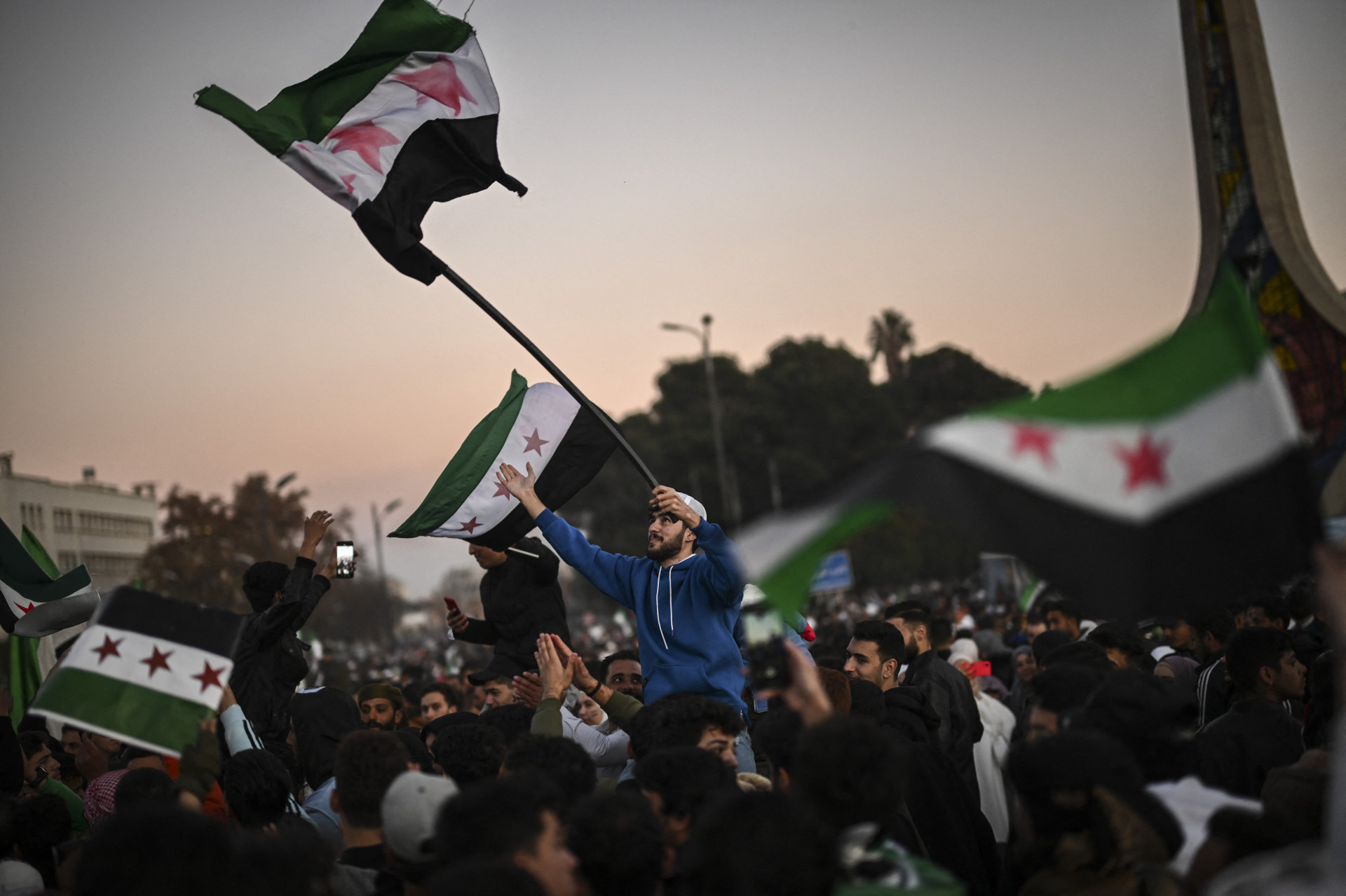 Multidões celebram a queda de Assad na Praça Umayyad, em Damasco, em 13 de dezembro de 2024 - AFP