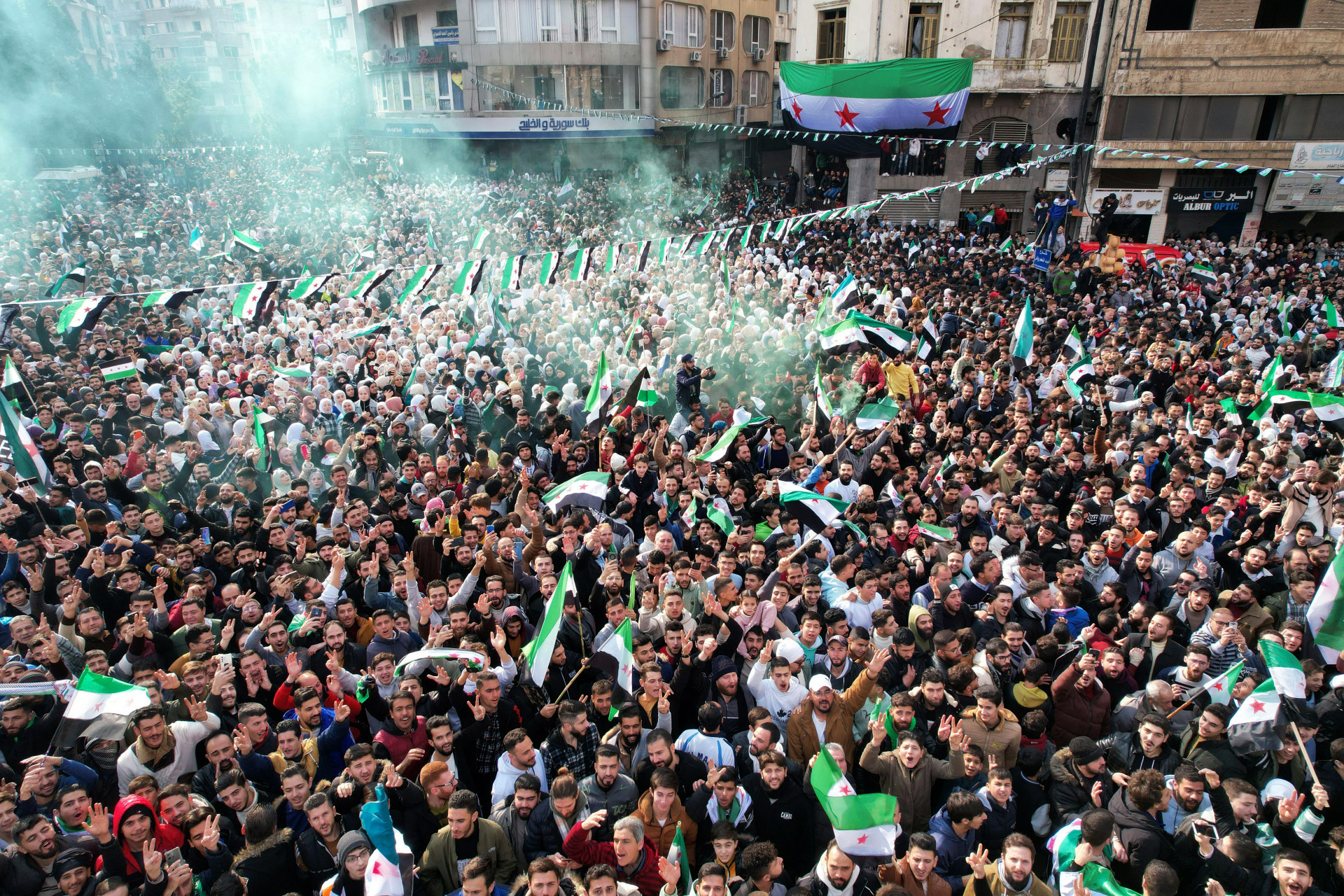 Multidões celebram a queda de Assad na Praça Umayyad, em Damasco, em 13 de dezembro de 2024 - AFP