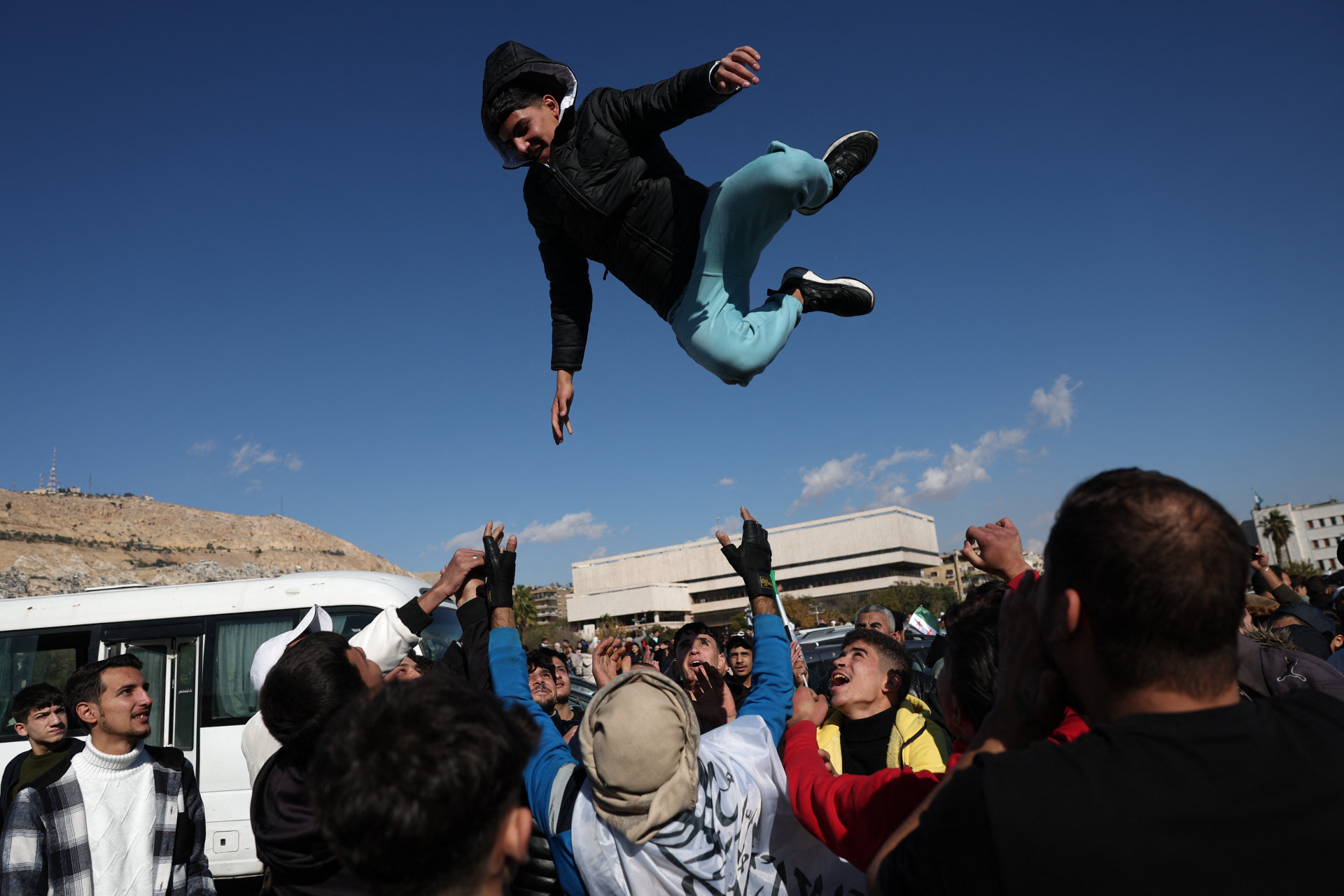 Multidões celebram a queda de Assad na Praça Umayyad, em Damasco, em 13 de dezembro de 2024 - AFP