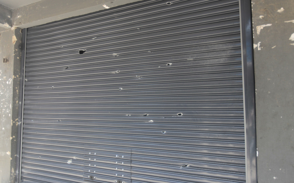 Portão de comércio ficou marcado de tiros após confronto na Rocinha