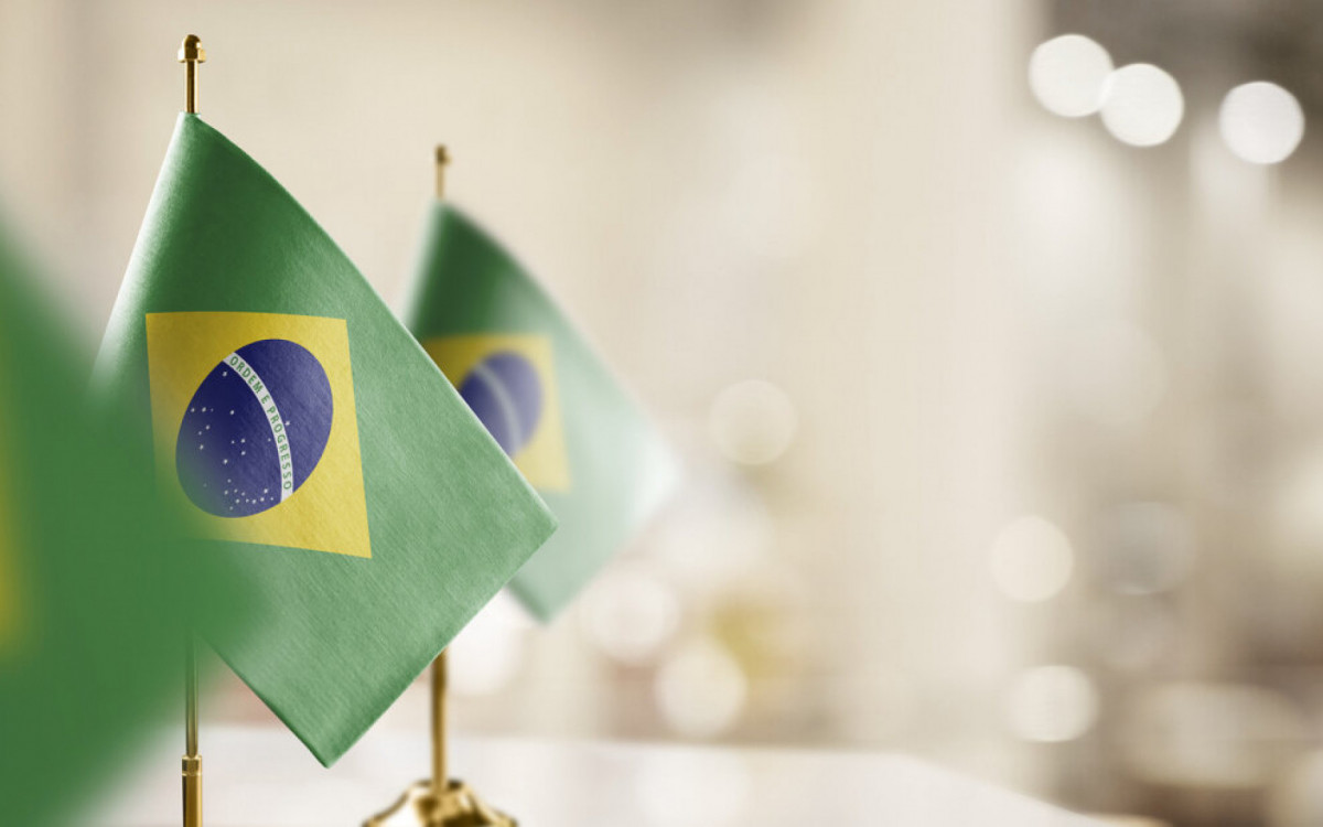 Small flags of the Brazil on an abstract blurry background