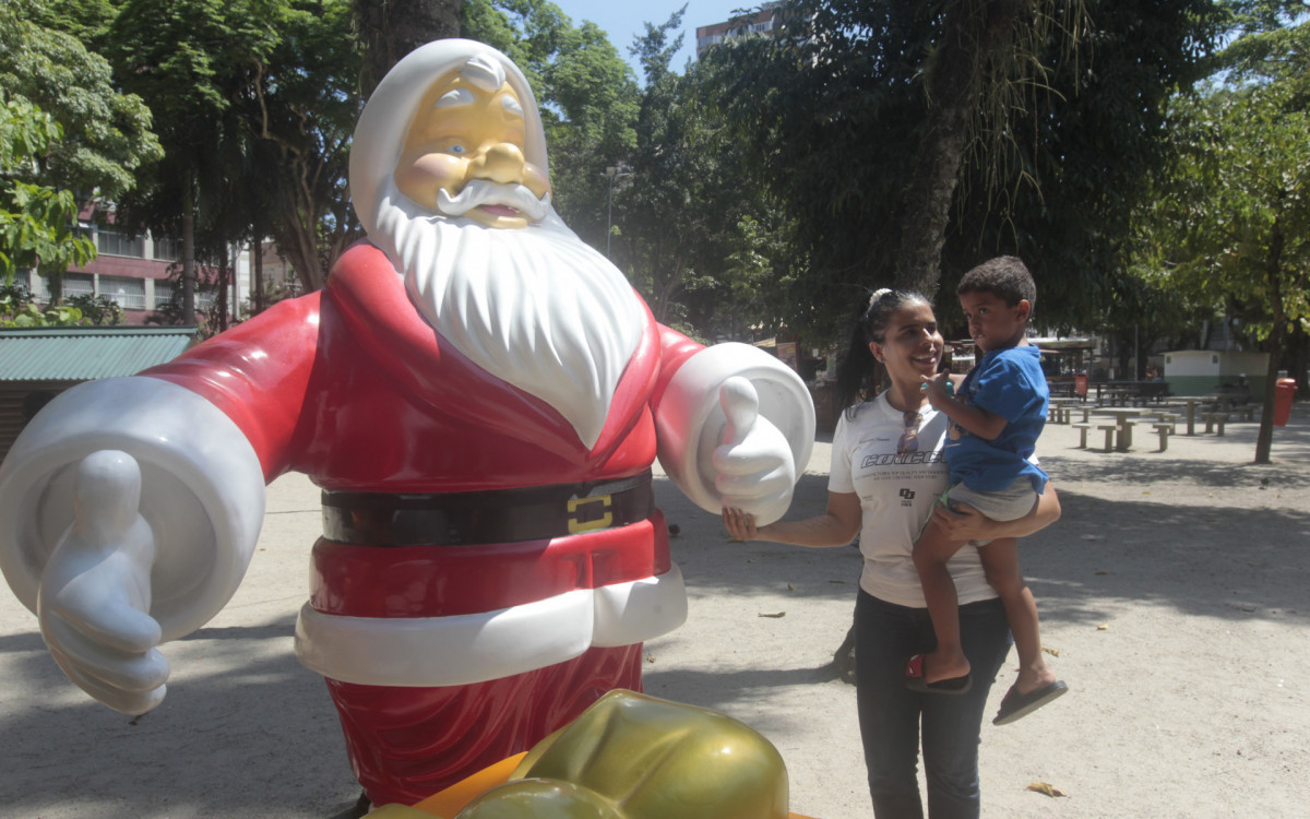 Tatiana Medeiros, 42, e seu filho, Samuel Coutinho, 6, ao lado de escultura do Papai Noel