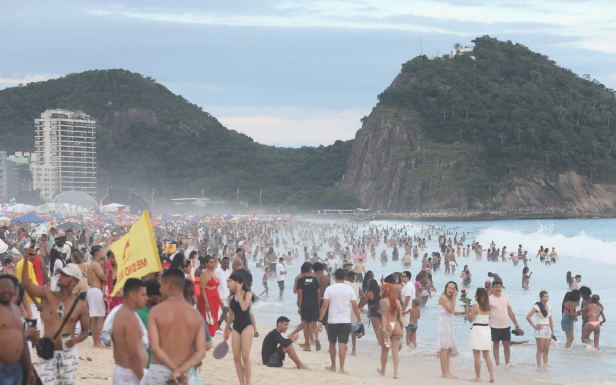 Cariocas e turistas aproveitam a Praia de Copacabana há poucas horas da virada do ano