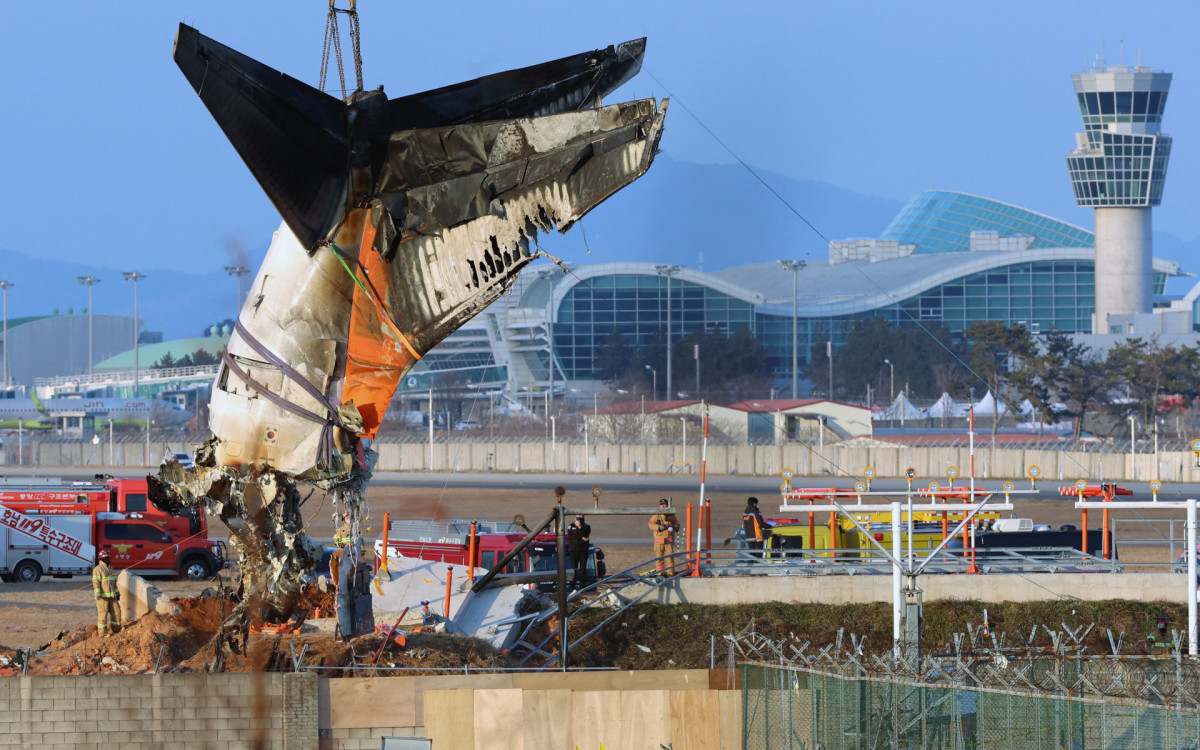 Guindaste levanta restos do avião durante a operação de salvamento da aeronave  - AFP