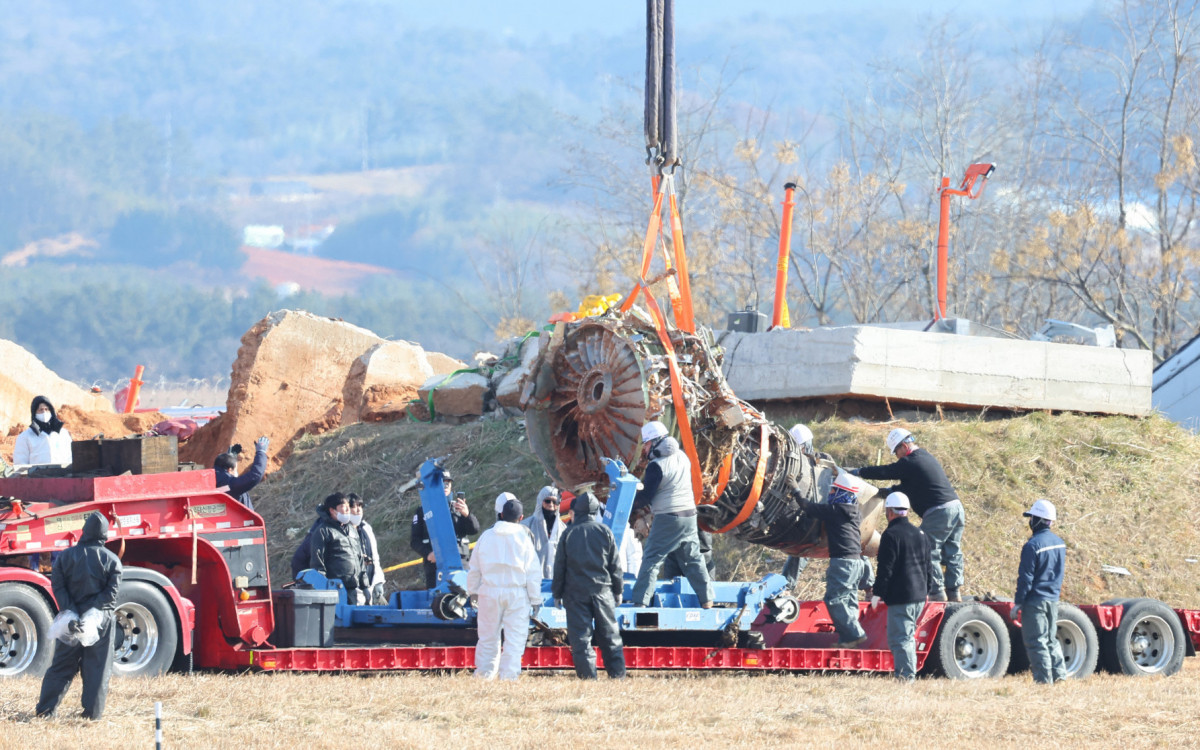 Guindaste levanta restos do avião durante a operação de salvamento da aeronave  - AFP