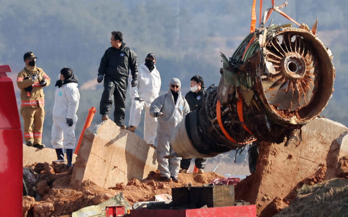 Guindaste levanta restos do avião durante a operação de salvamento da aeronave  - AFP