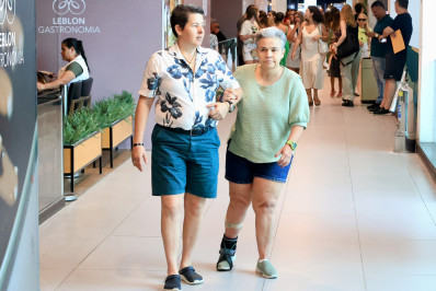 Longe da TV, Claudia Rodrigues passeia com a noiva por shopping da Zona Sul