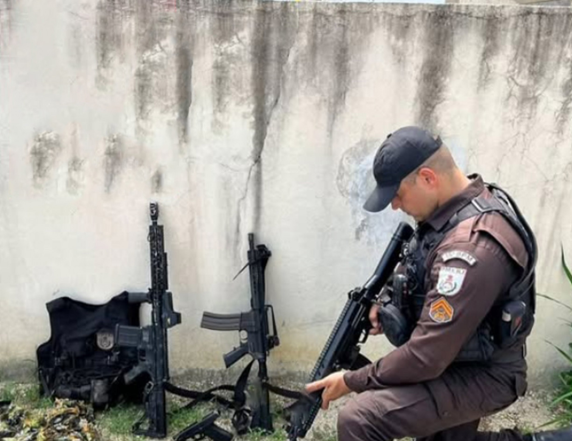 Agentes encontraram dois fuzis, uma pistola, capa de colete e munições no carro do PM - Reprodução