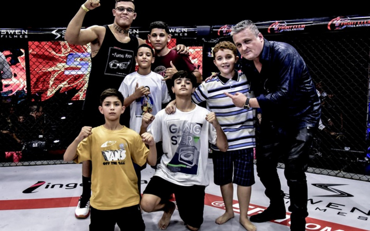 David Hudson celebra com crianças no cage do SFT ao lado do lutador Caio Borralho