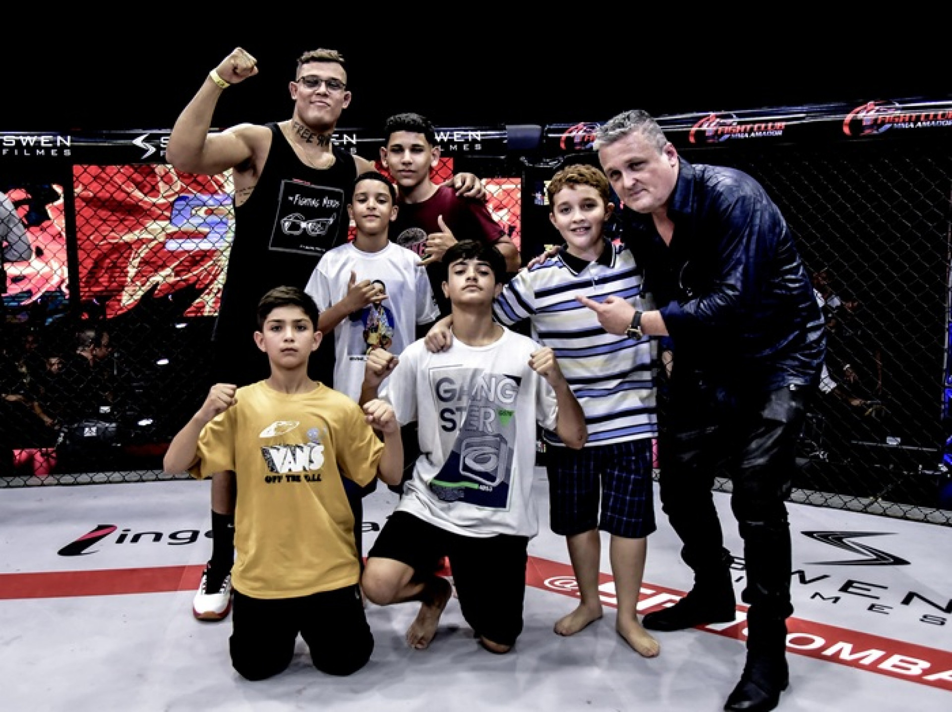 David Hudson celebra com crian&ccedil;as no cage do SFT ao lado do lutador Caio Borralho   -  (Foto: Reprodu&ccedil;&atilde;o)