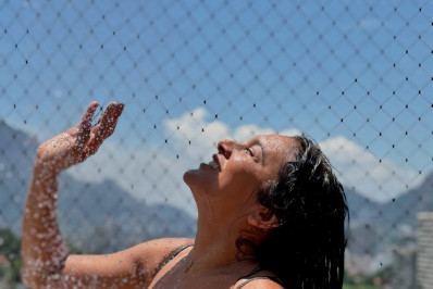 De maiô, Dira Paes alivia o calor com banho de chuveiro