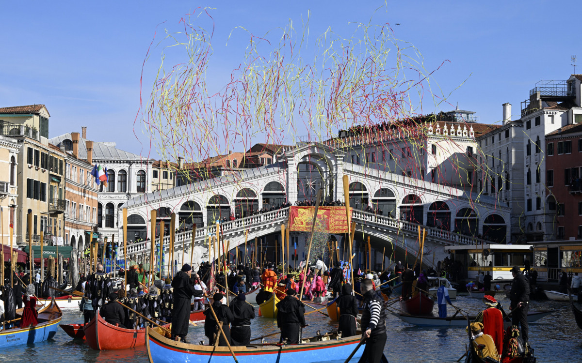 Confetes explodem enquanto barcos decorados navegam no Grande Canal