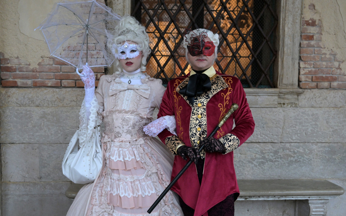 Foliões vestindo trajes de época posam durante o tradicional Carnaval de Veneza