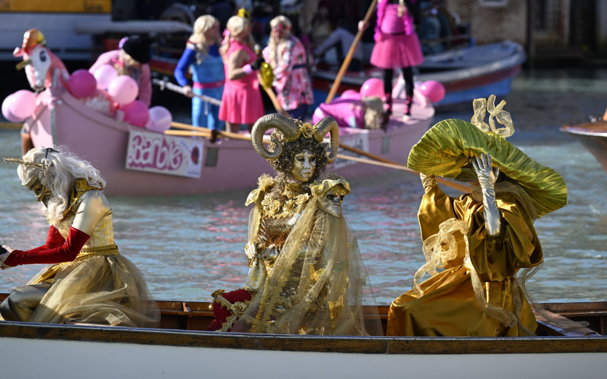 Foliões remam durante um desfile no Grande Canal no Carnaval de Veneza