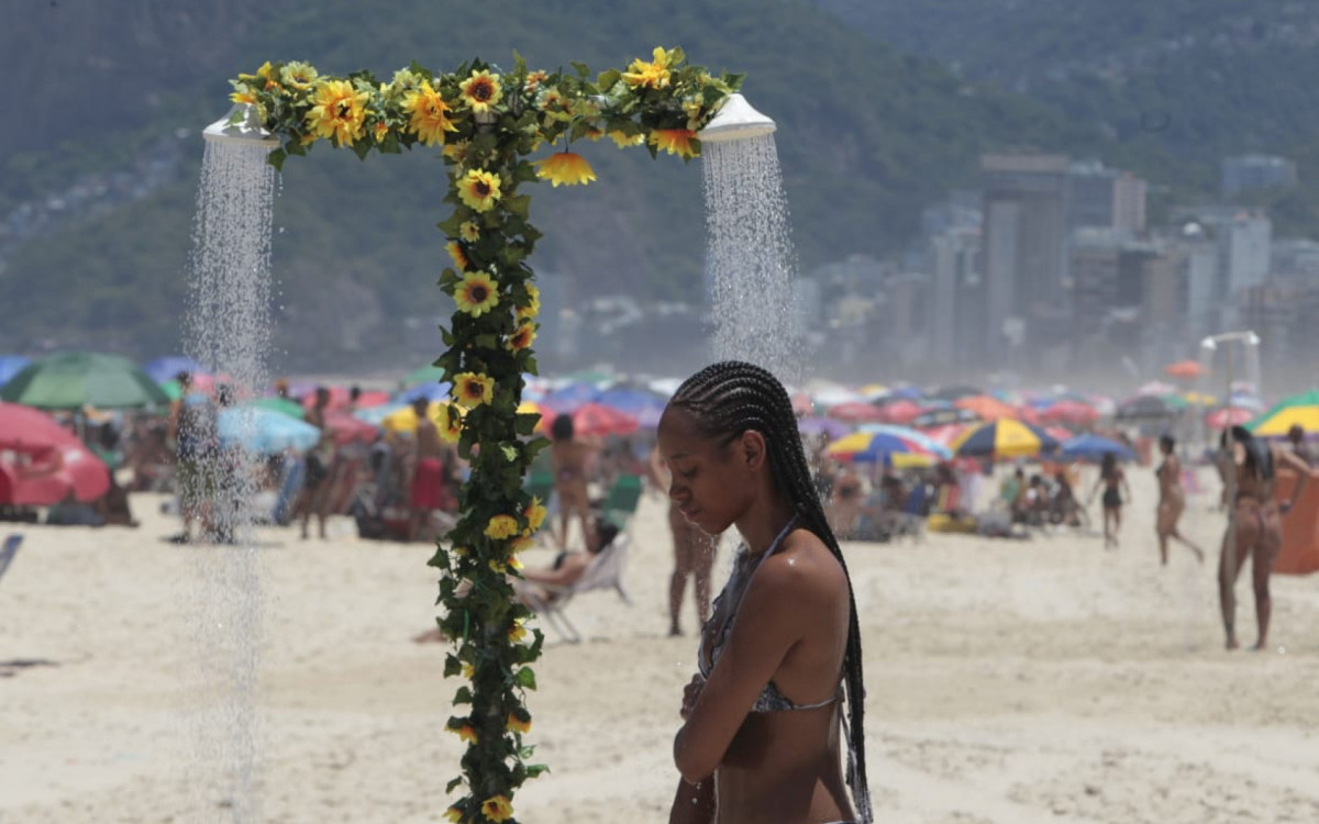 Visitantes buscam maneiras de se refrescar na Praia de Ipanema, na Zona Sul