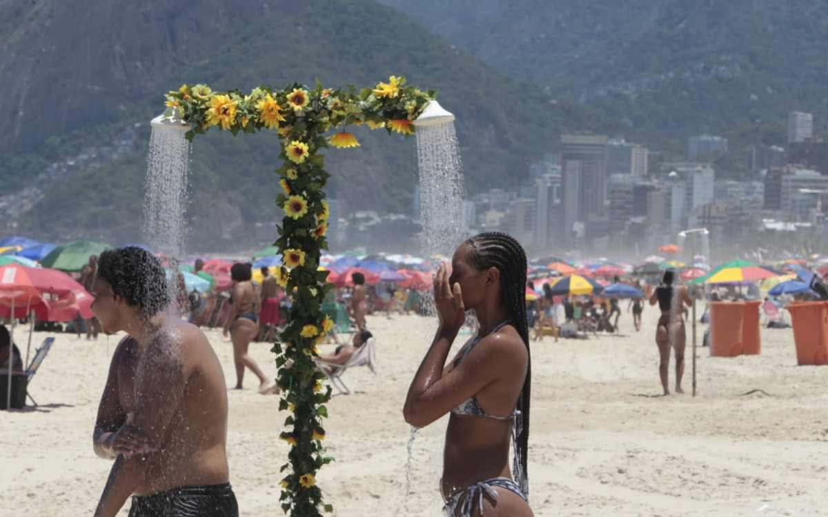 Visitantes buscam maneiras de se refrescar na Praia de Ipanema, na Zona Sul