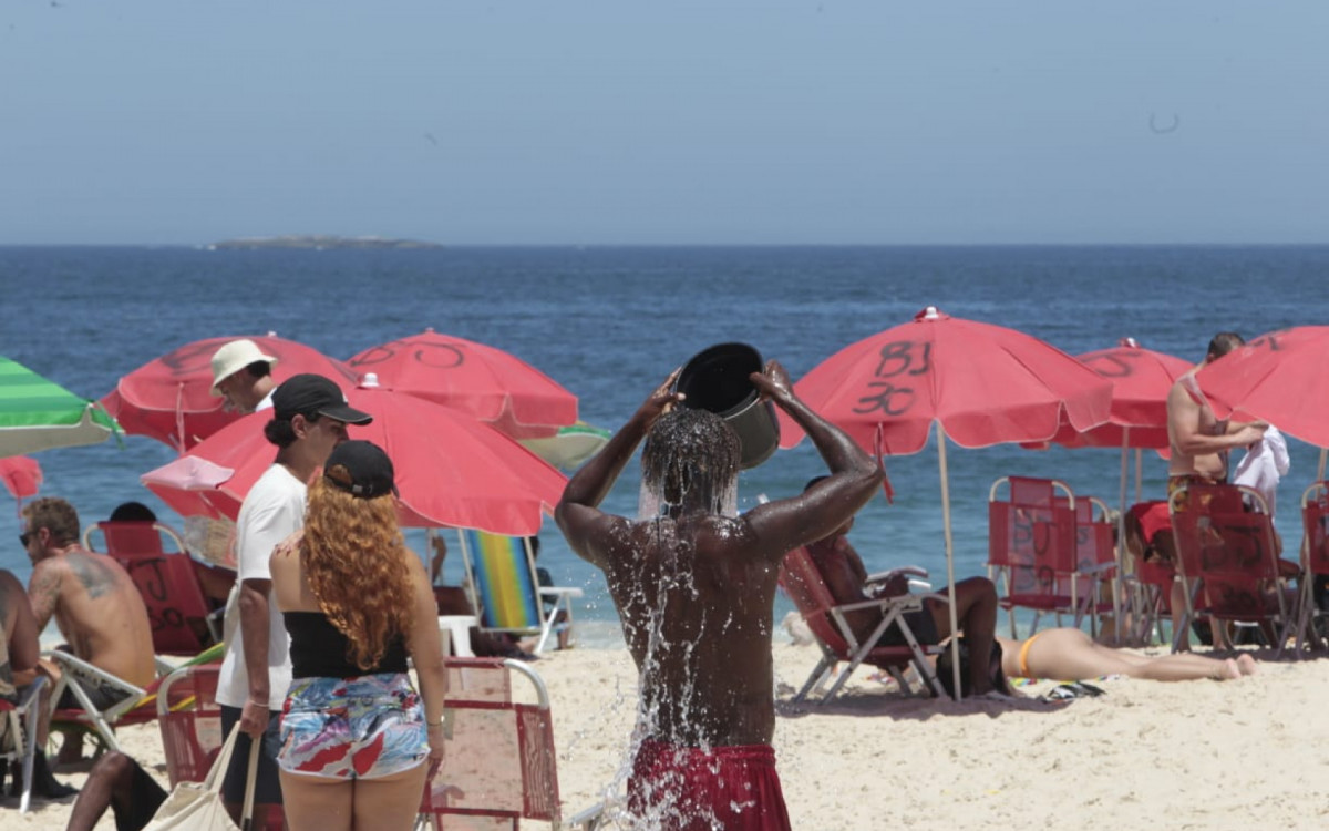 Visitantes buscam maneiras de se refrescar na Praia de Ipanema, na Zona Sul