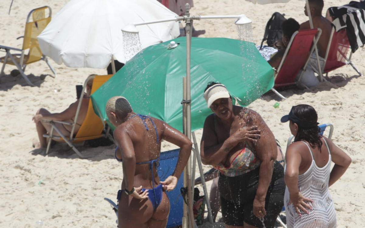 Visitantes buscam maneiras de se refrescar na Praia de Ipanema, na Zona Sul