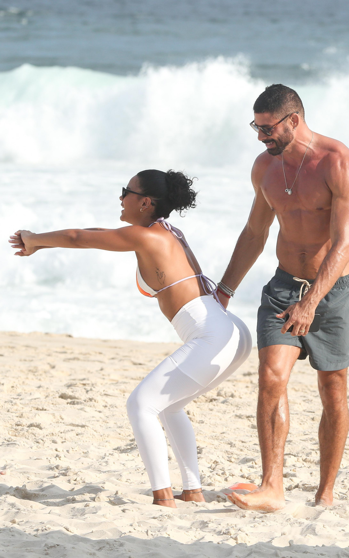 Bella Campos e Cauã Reymond exibem boa forma em gravação de \'Vale Tudo\' na praia
