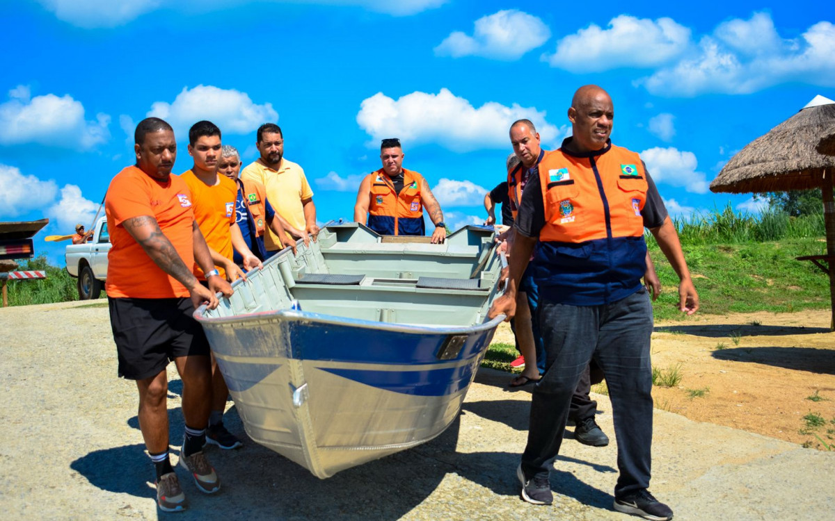Agentes da Defesa Civil manejam um dos barcos usado no simulado