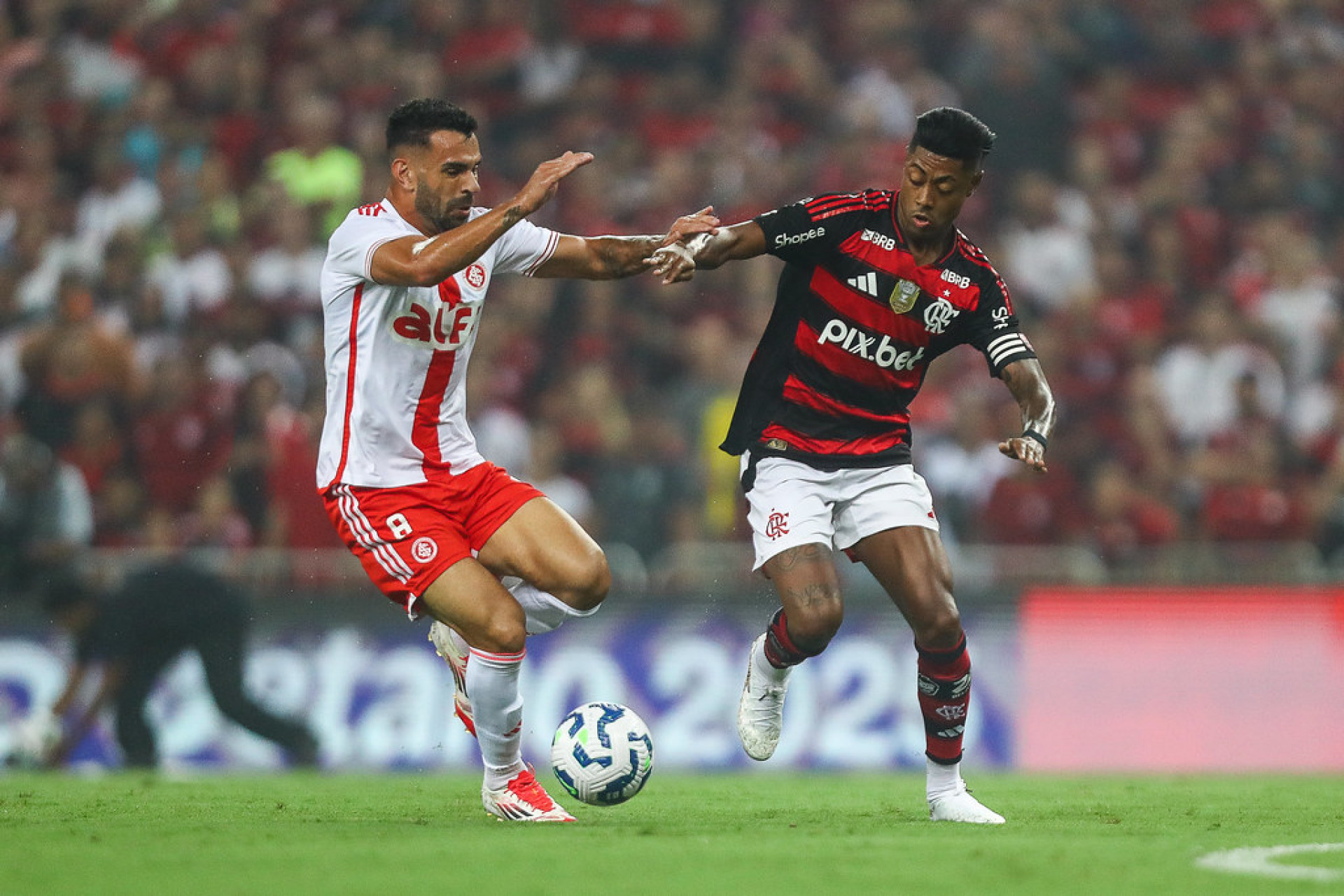 Em um duelo de xarás, o Bruno Henrique do Internacional leva vantagem sobre o Bruno Henrique do Flamengo e fica com a bola - Gilvan de Souza / Flamengo