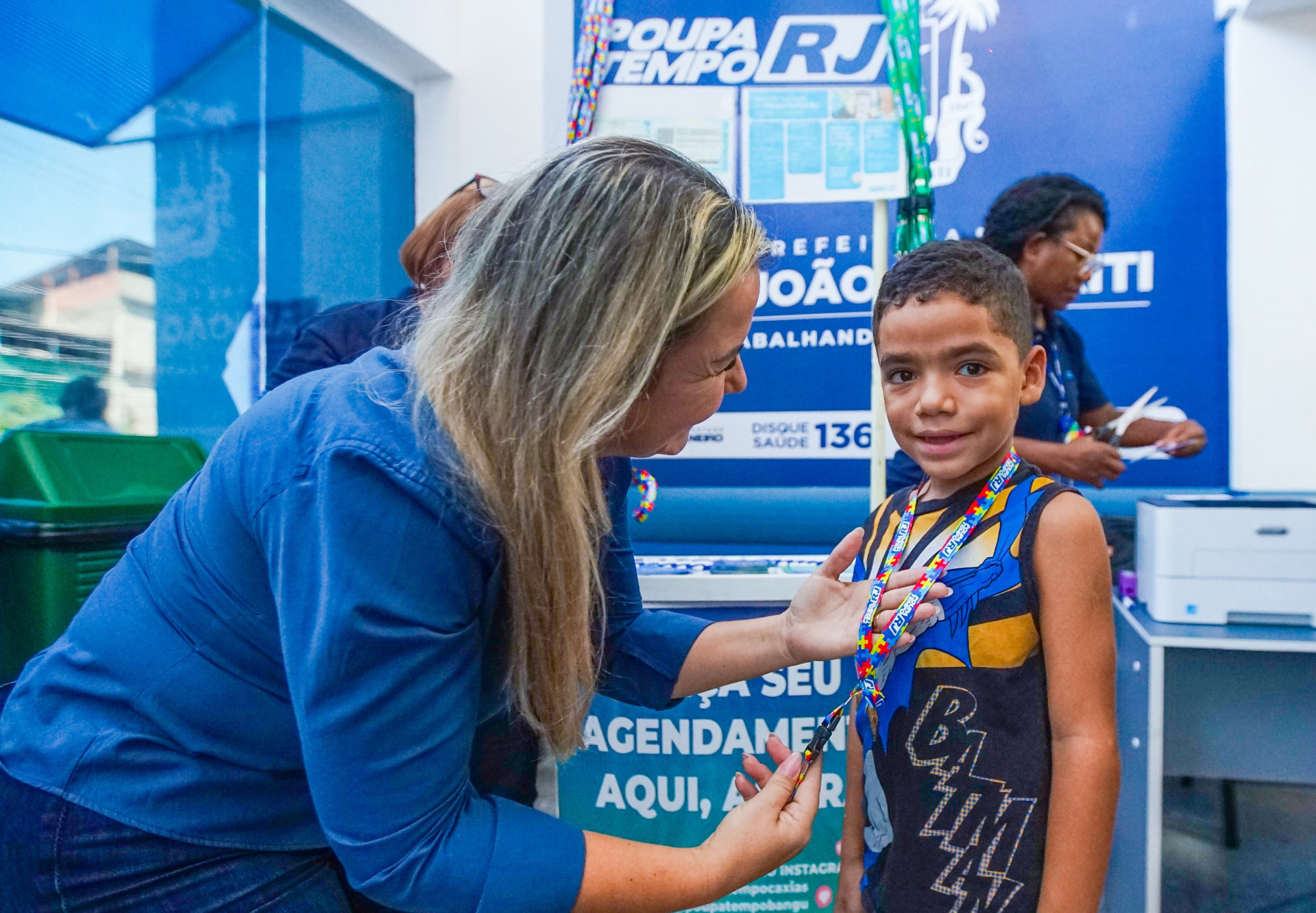 A coordenadora do CER, Viviane Alves Costa entregando a cordinha de identifica&ccedil;&atilde;o de crian&ccedil;as com Transtorno do Espectro Autista (TEA) - Gilberto Rocha
