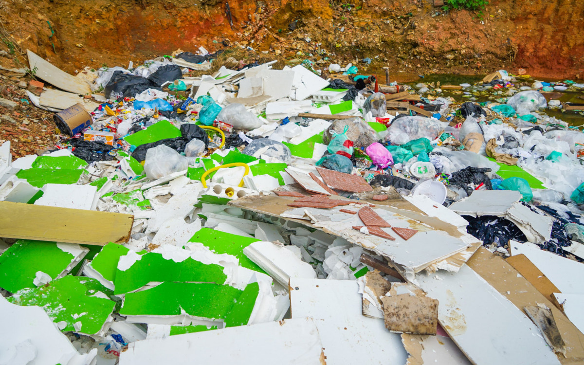 O terreno que serviu como ponto irregular de descarte está localizado em frente ao estabelecimento no bairro Vilar dos Teles