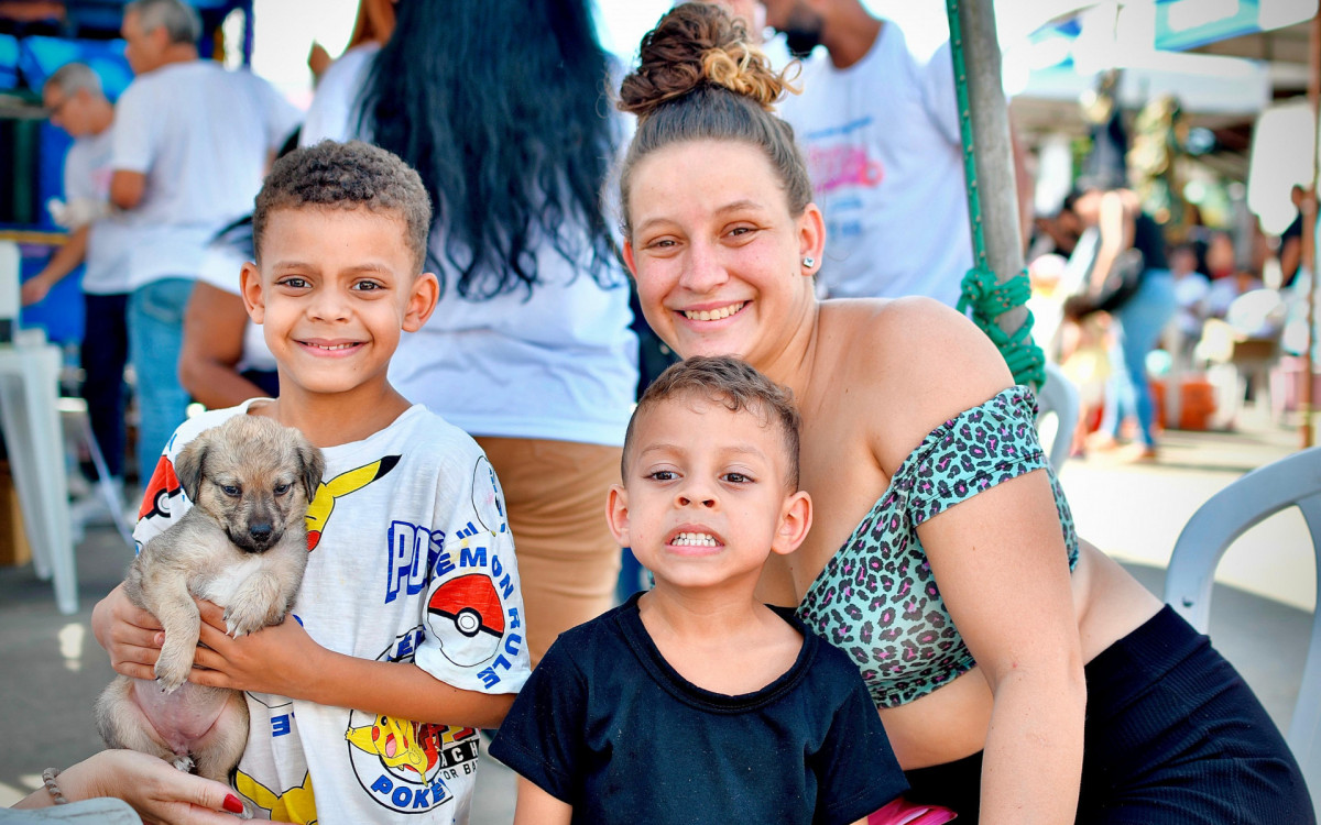 Tuane Marcela Novaes, com os filhos, moradora do bairro Vila Entre Rios, feliz com o cachorro mestiço adotado