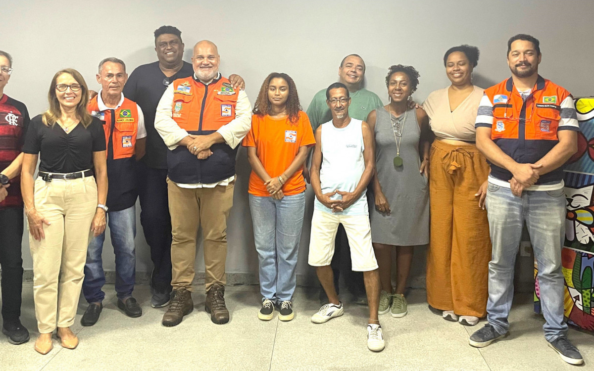 Agentes da Defesa Civil com o pessoal da comunidade escolar no evento