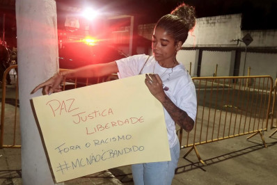 Vivi Noronha posa com cartazes em frente ao presídio onde está MC Poze do Rodo