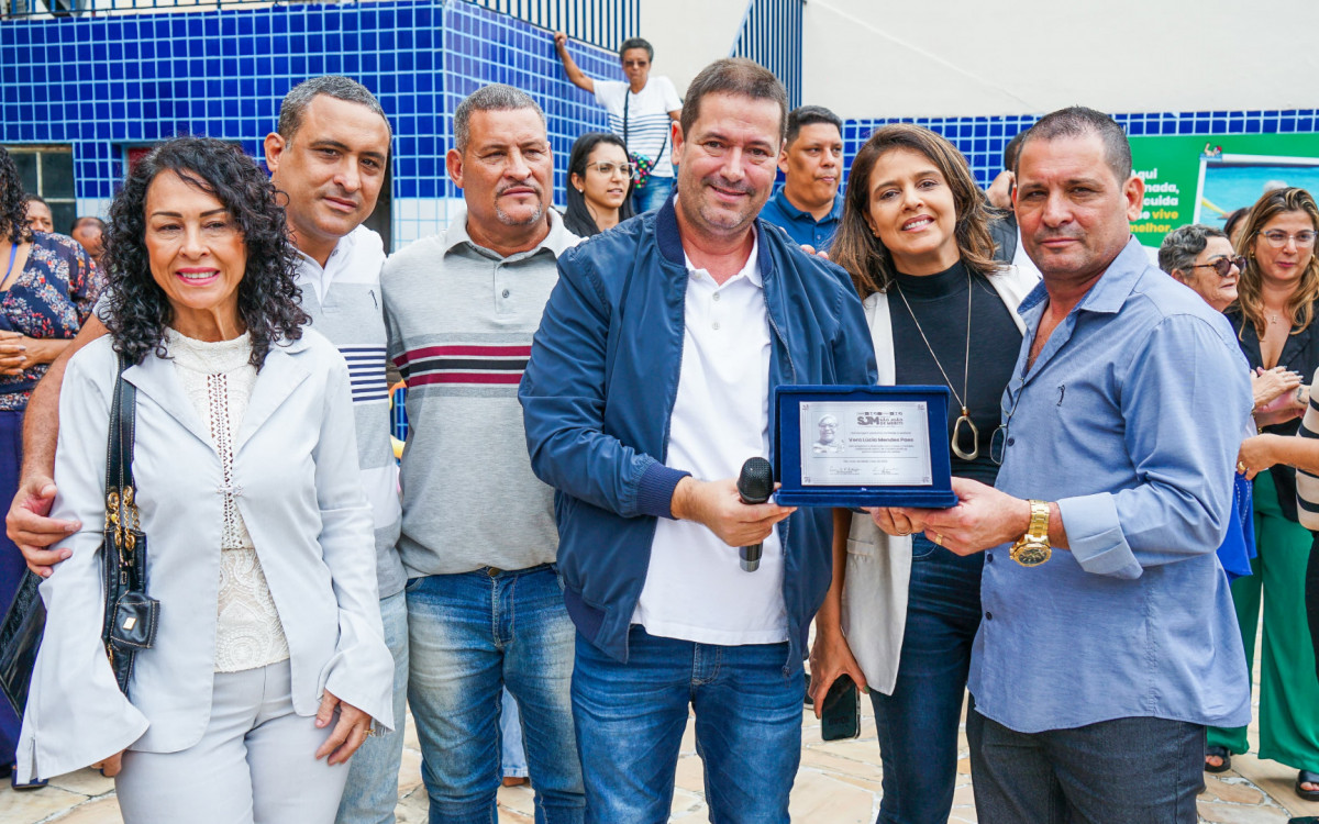 Prefeito Léo Vieira (centro) entregou uma placa de homenagem ao vereador Rogério Paes, filho da homenageada, acompanhado de familiares 