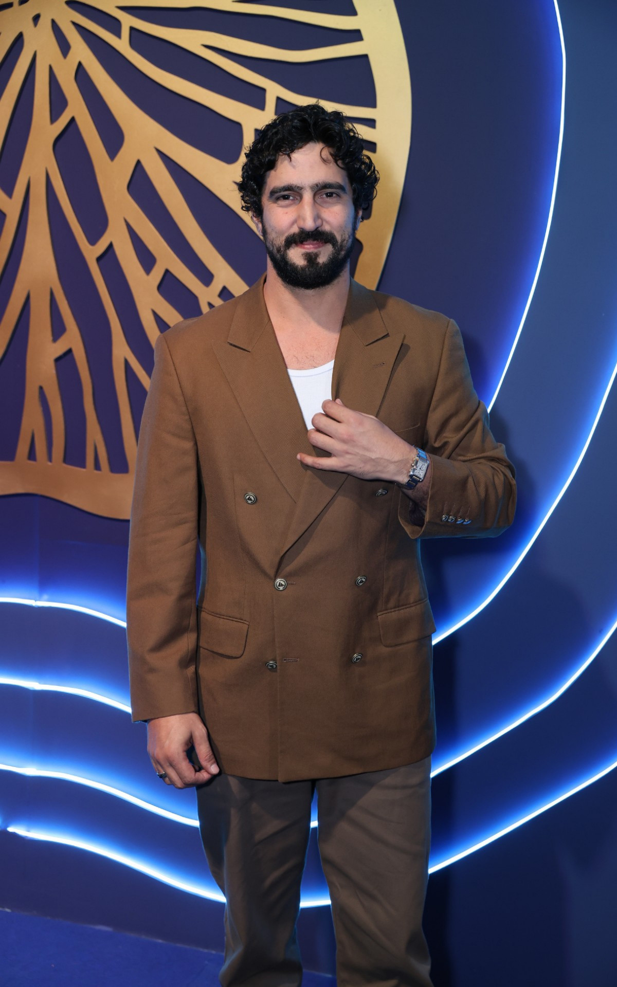 Renato Goés apareceu com um look bege e uma camisa branca 