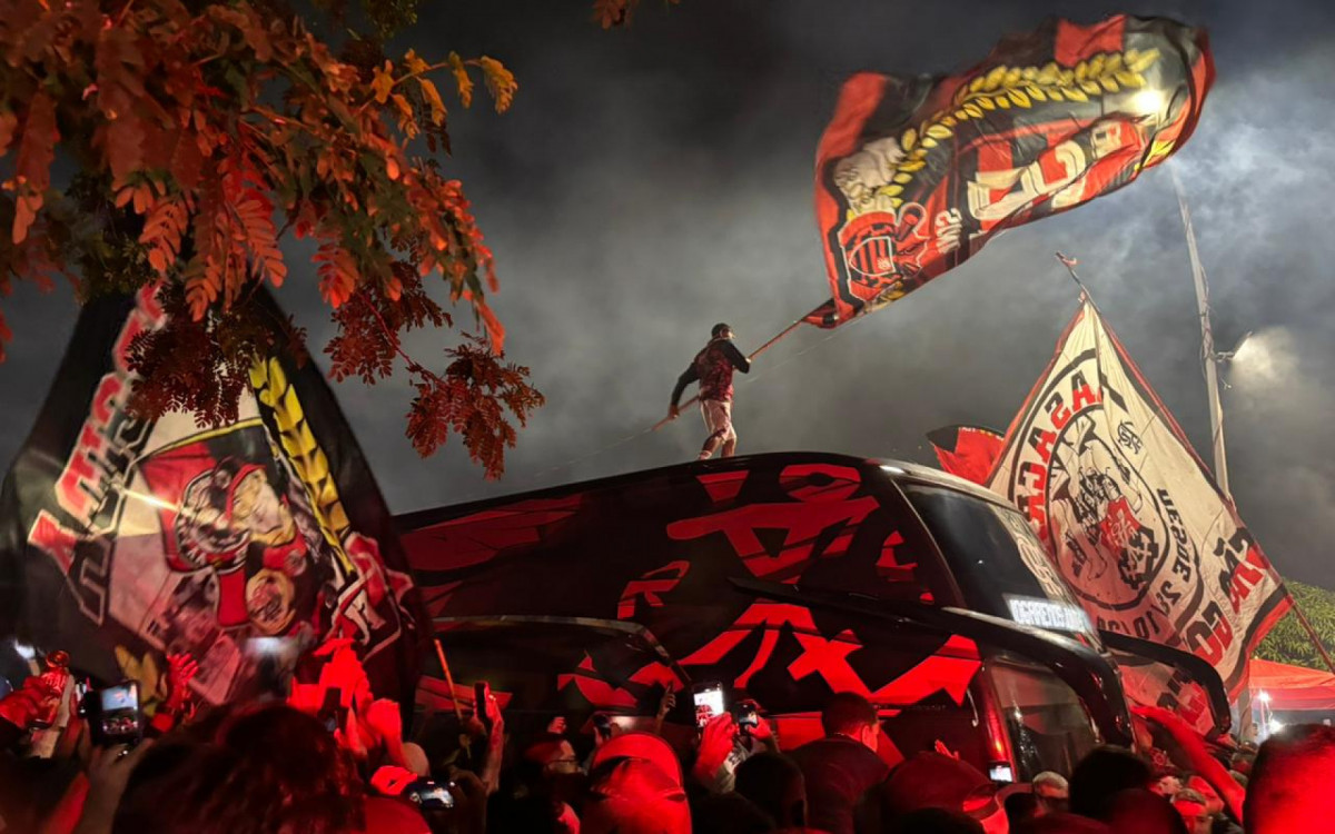 Torcedor do Flamengo sobe no ônibus em festa no Galeão