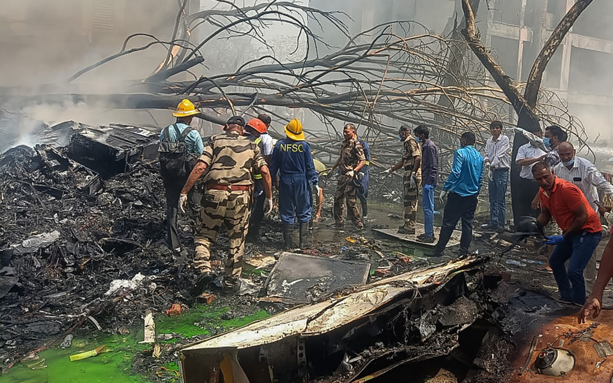 Bombeiros trabalham no local do acidente de avião na Índia - AFP