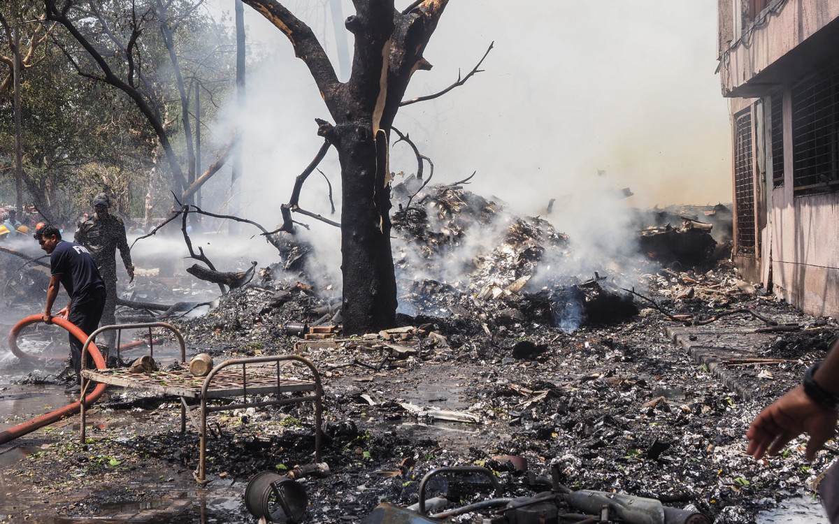 Bombeiros trabalham no local do acidente de avião na Índia - AFP