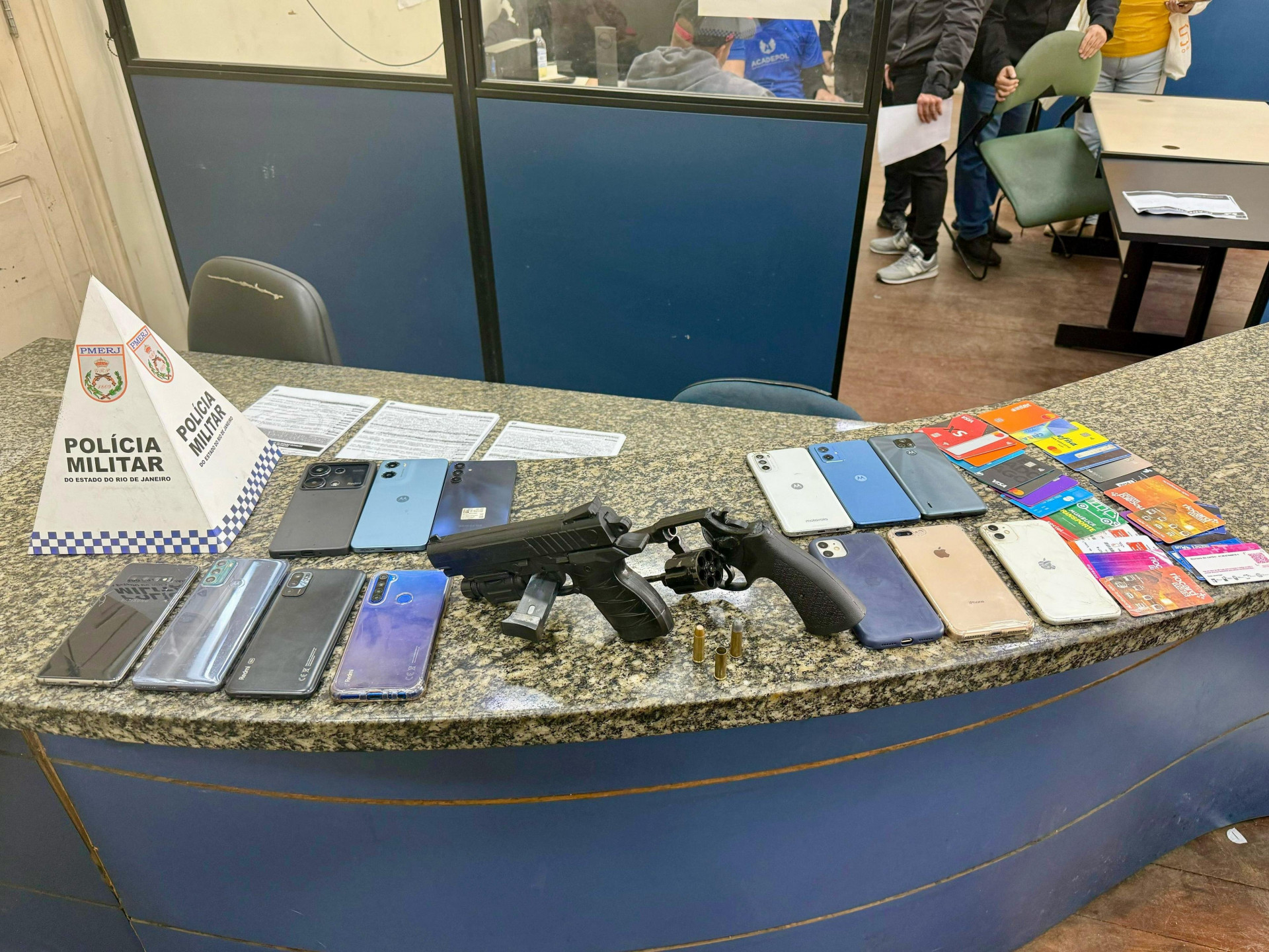 Foram apreendidos um revólver calibre 38, uma réplica de pistola, 13 aparelhos celulares e 25 cartões magnéticos - Divulgação / Polícia Militar