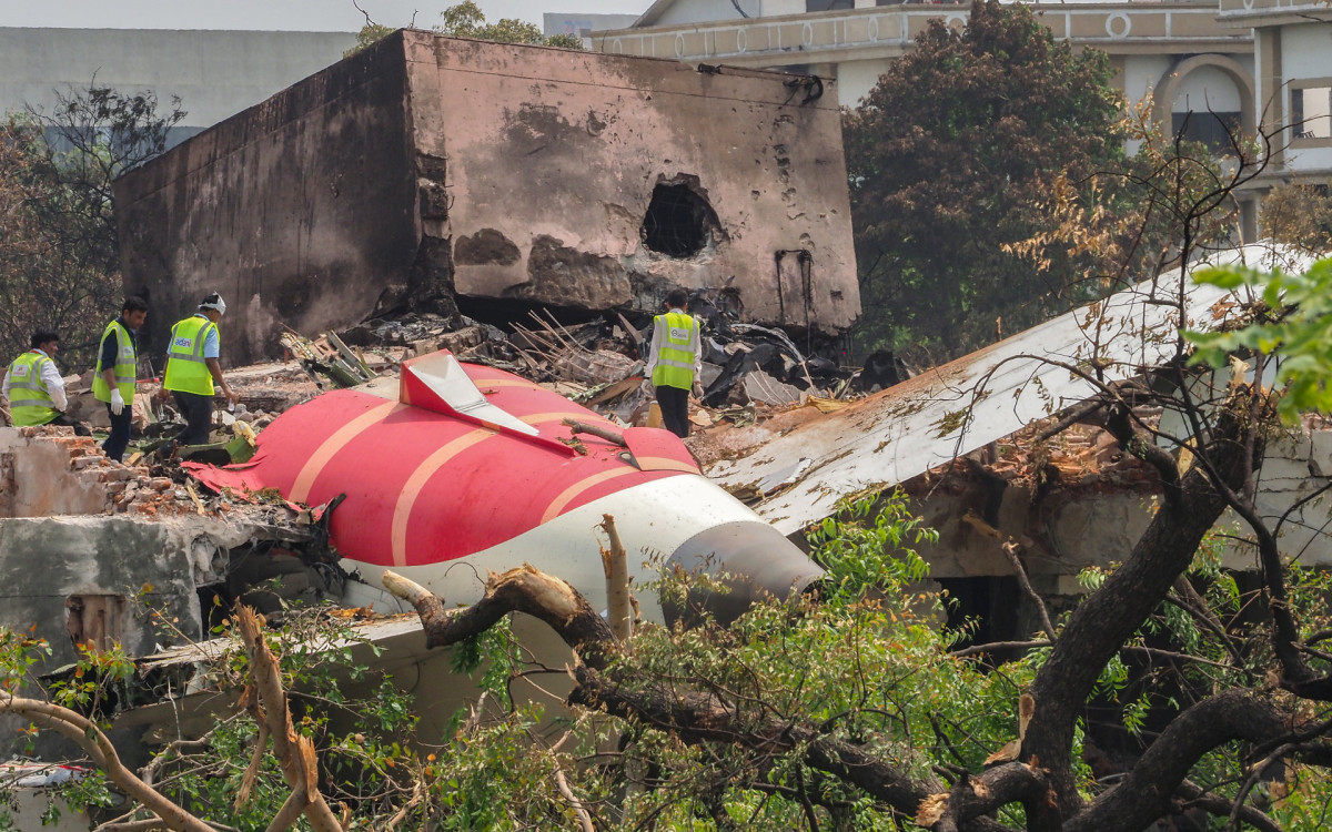 Equipe de investigação inspeciona os destroços do avião na India um dia após a queda - AFP
