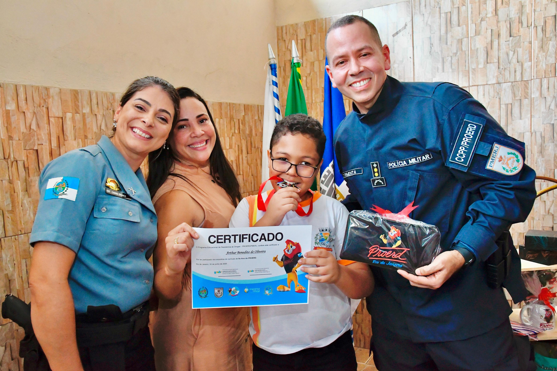 Sargento Carina, gestora Gisele e o coordenador do Proerd, Carlos Pimenta, com o aluno Arthur Benedito   - Jeovani Campos / PMBR