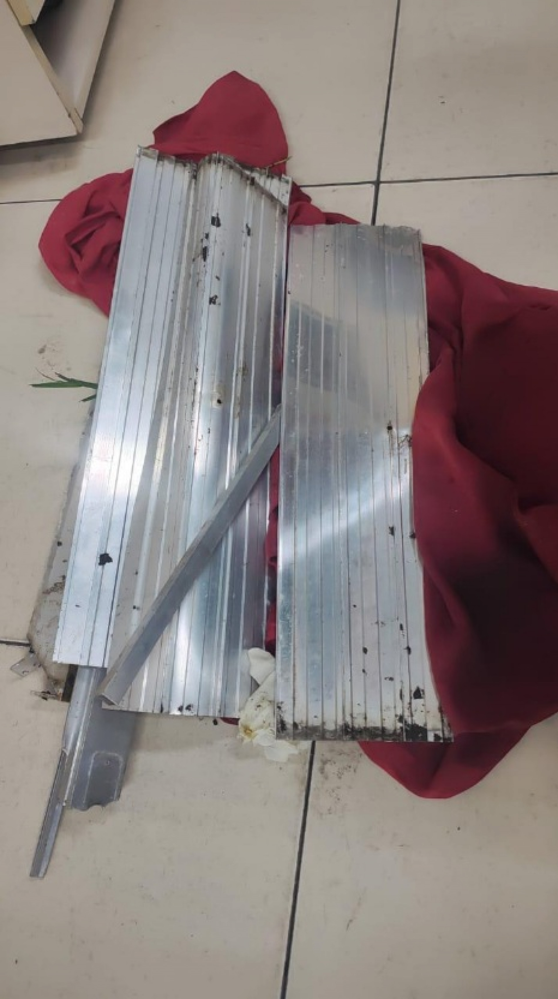 Os criminosos carregavam partes do portão furtado em um pano vermelho