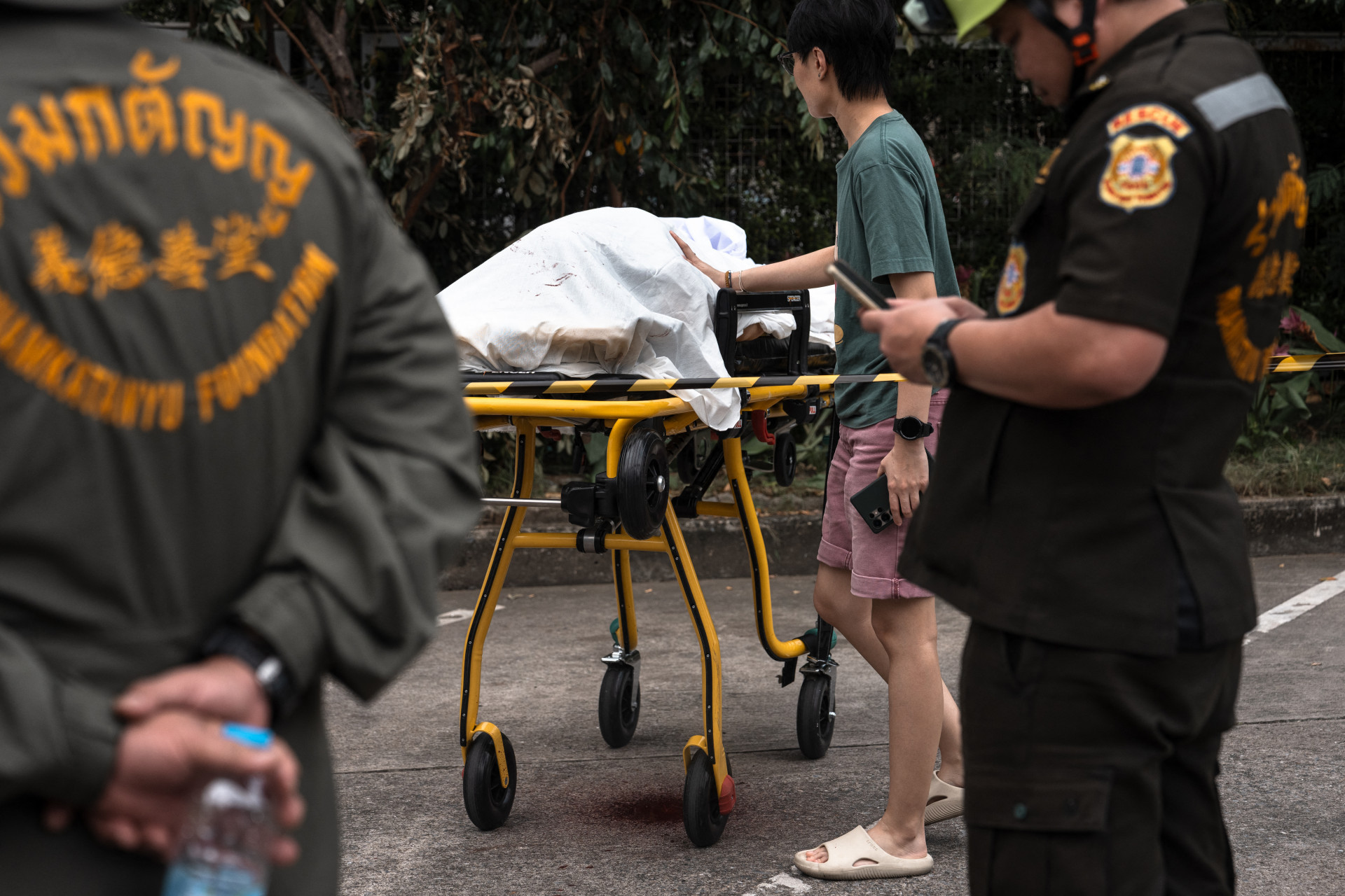 Jovem encosta em corpo de vítima coberto - Chanakarn Laossarakham/AFP/Agência O Dia