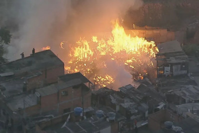 Incêndio de grandes proporções atinge casas em comunidade na Grande SP; homem é hospitalizado