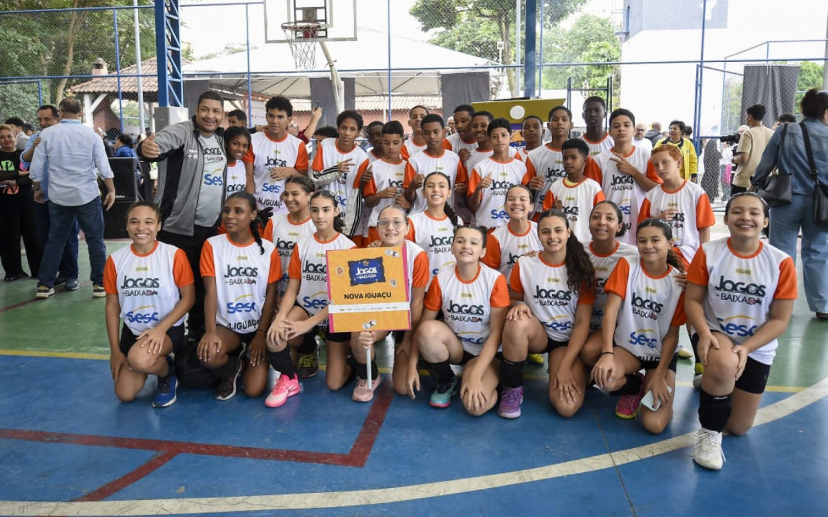 Equipe de vôlei posa para foto antes da disputa, representando o município nos Jogos da Baixada.
