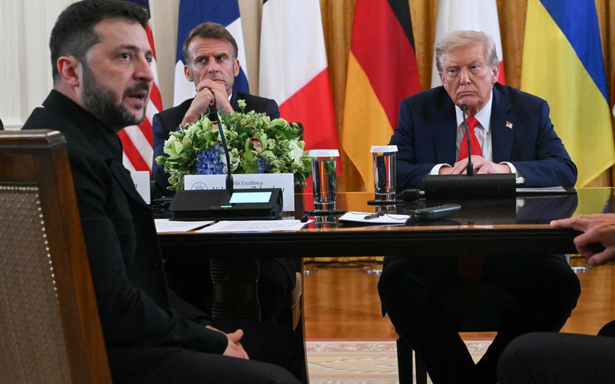 Presidente ucraniano Volodymyr Zelensky discursa enquanto Emmanuel Macron e Donald Trump ouvem durante uma reunião com líderes europeus