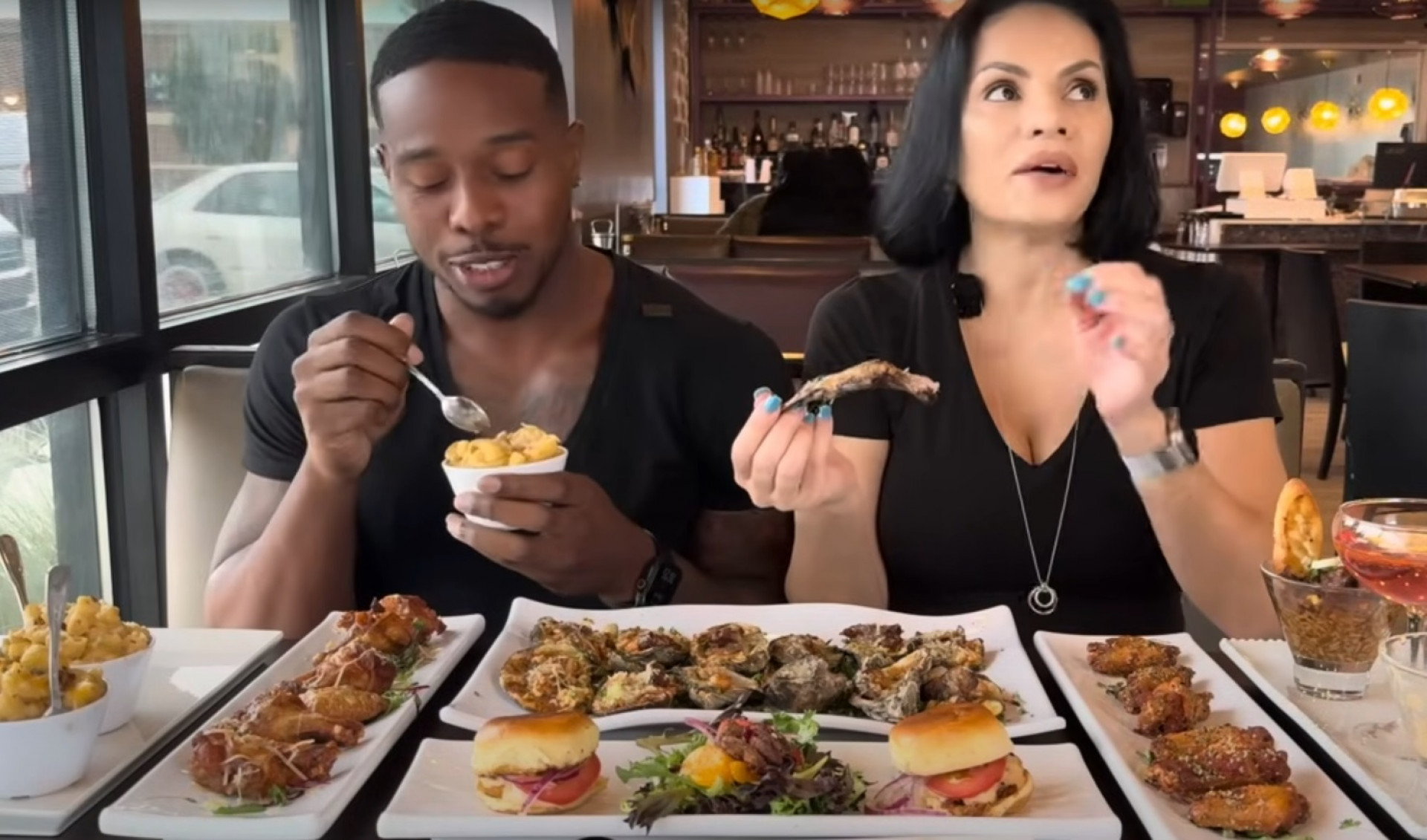 Momentos antes do carro invadir o restaurante, os influenciadores experimentavam a comida do local - Reprodução / YouTube