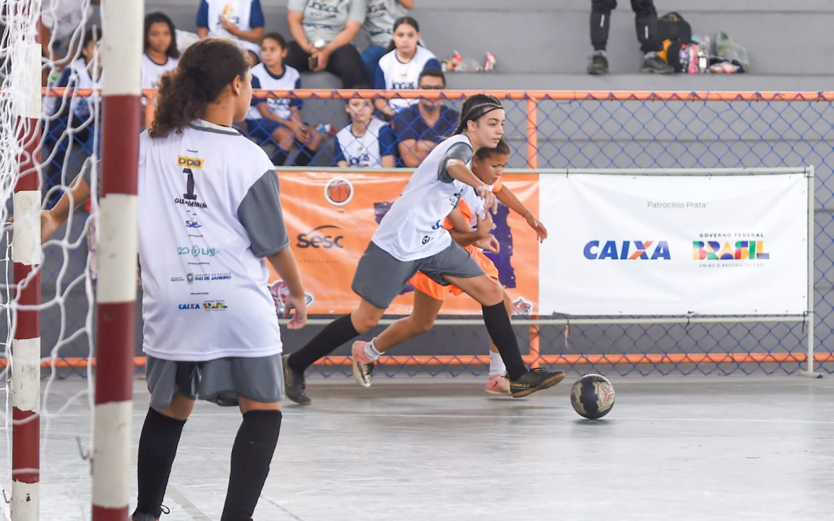 Marcação cerrada: duelo intenso entre as equipes no futsal.