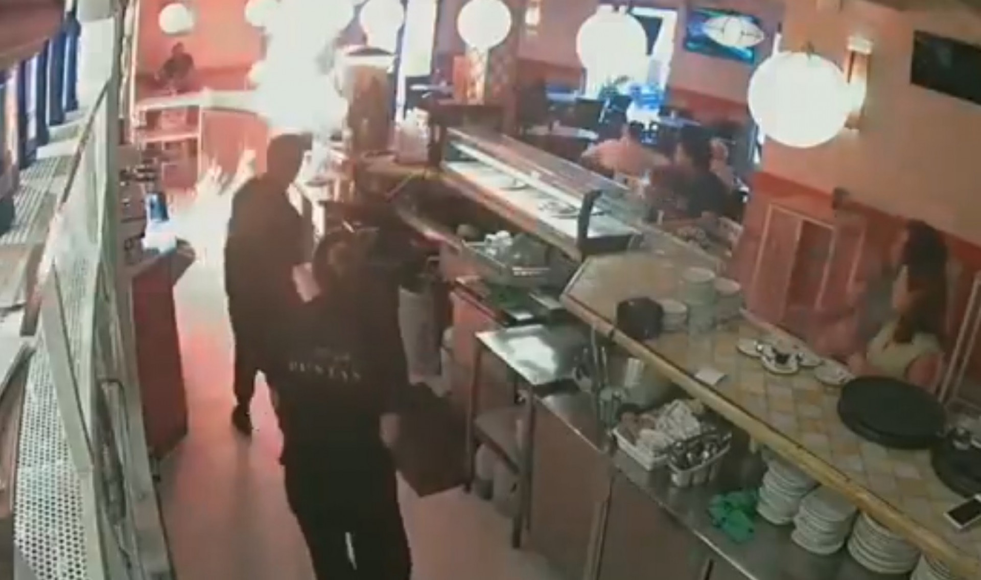 Momento em que homem ateia fogo em bancada de restaurante na Espanha