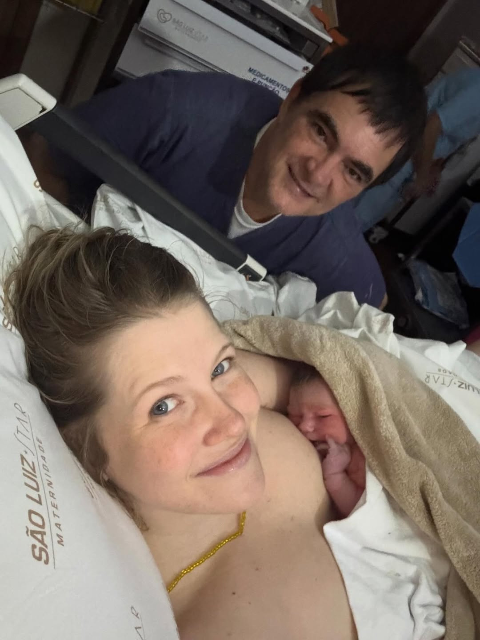 Samuel Rosa ao fundo e Laura Sarkovas com Dora em seus braços. - Reprodução/Instagram