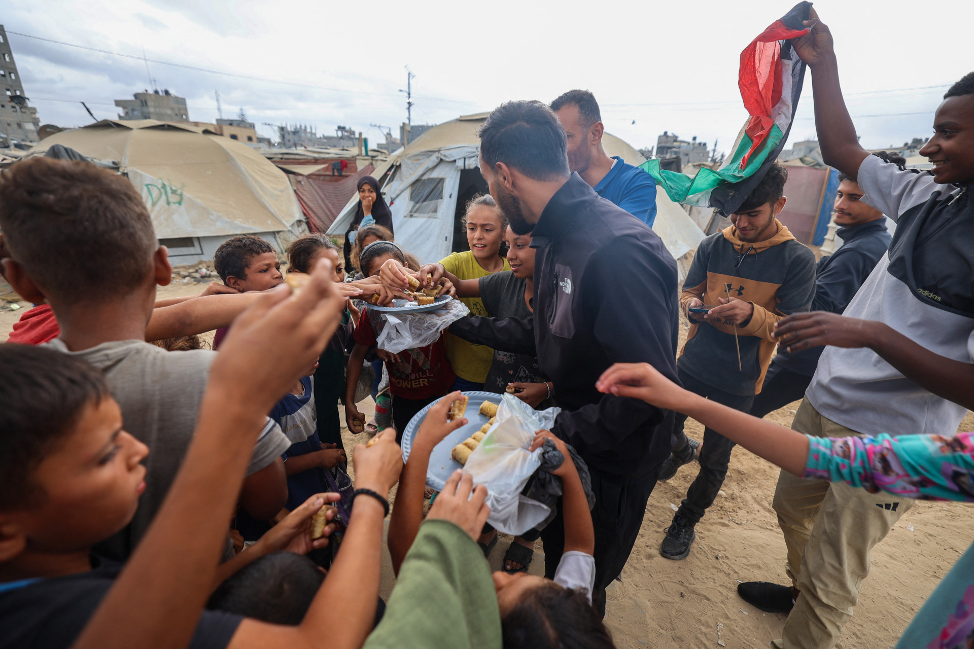 Um homem distribuiu doces para as crianças, após o anúncio do cessar-fogo - Bashar Taleb / AFP