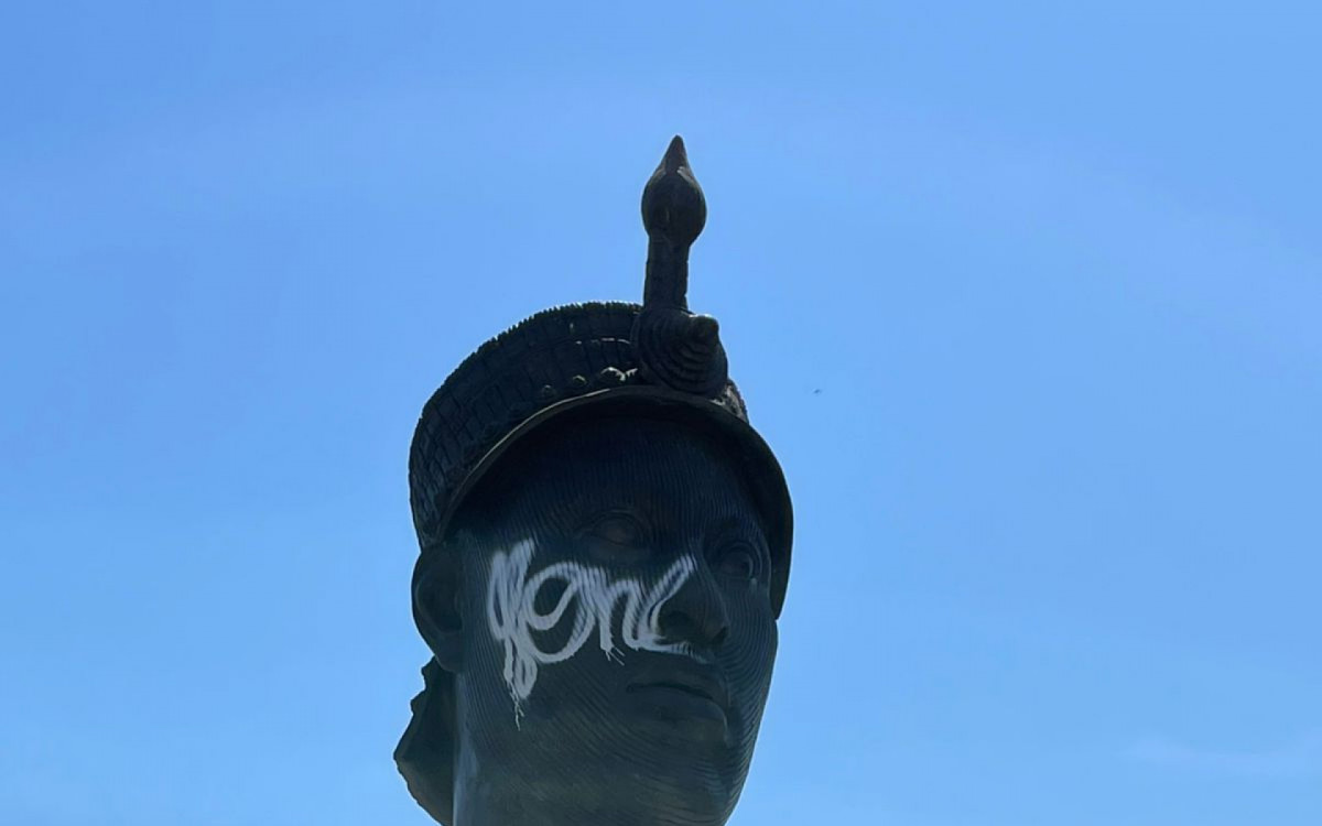 O rosto da est&aacute;tua foi pichado no rosto com uma tinta branca
