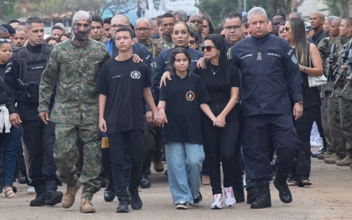 Coronel Menezes (D), secretário de Polícia Militar, consola a viúva do agente, Jéssica Araújo, que foi acompanhada dos filhos